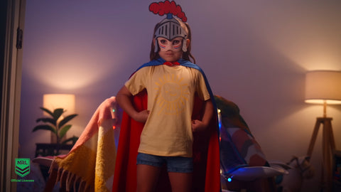 Girl wearing the Newcastle Knights NRL mask and youth supporter cape