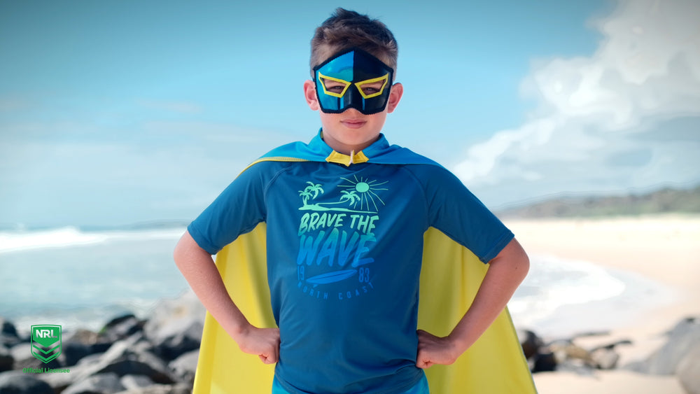 Boy wearing the Gold Coast Titans NRL mask and youth supporter cape