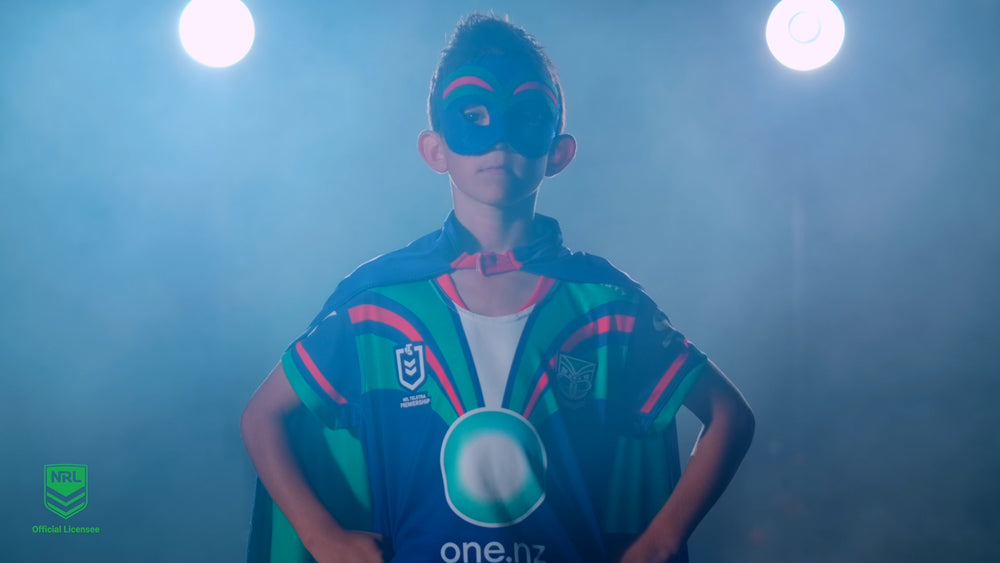Boy wearing the New Zealand Warriors NRL mask and youth support cape