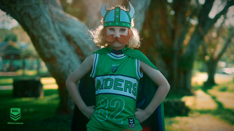 Boy wearing the Canberra Raiders NRL mask and youth supporter cape