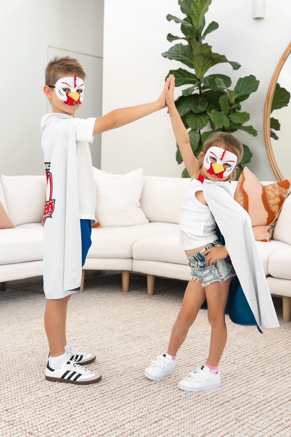 Boy and girl wearing the Sydney Roosters NRL mask and youth supporter cape
