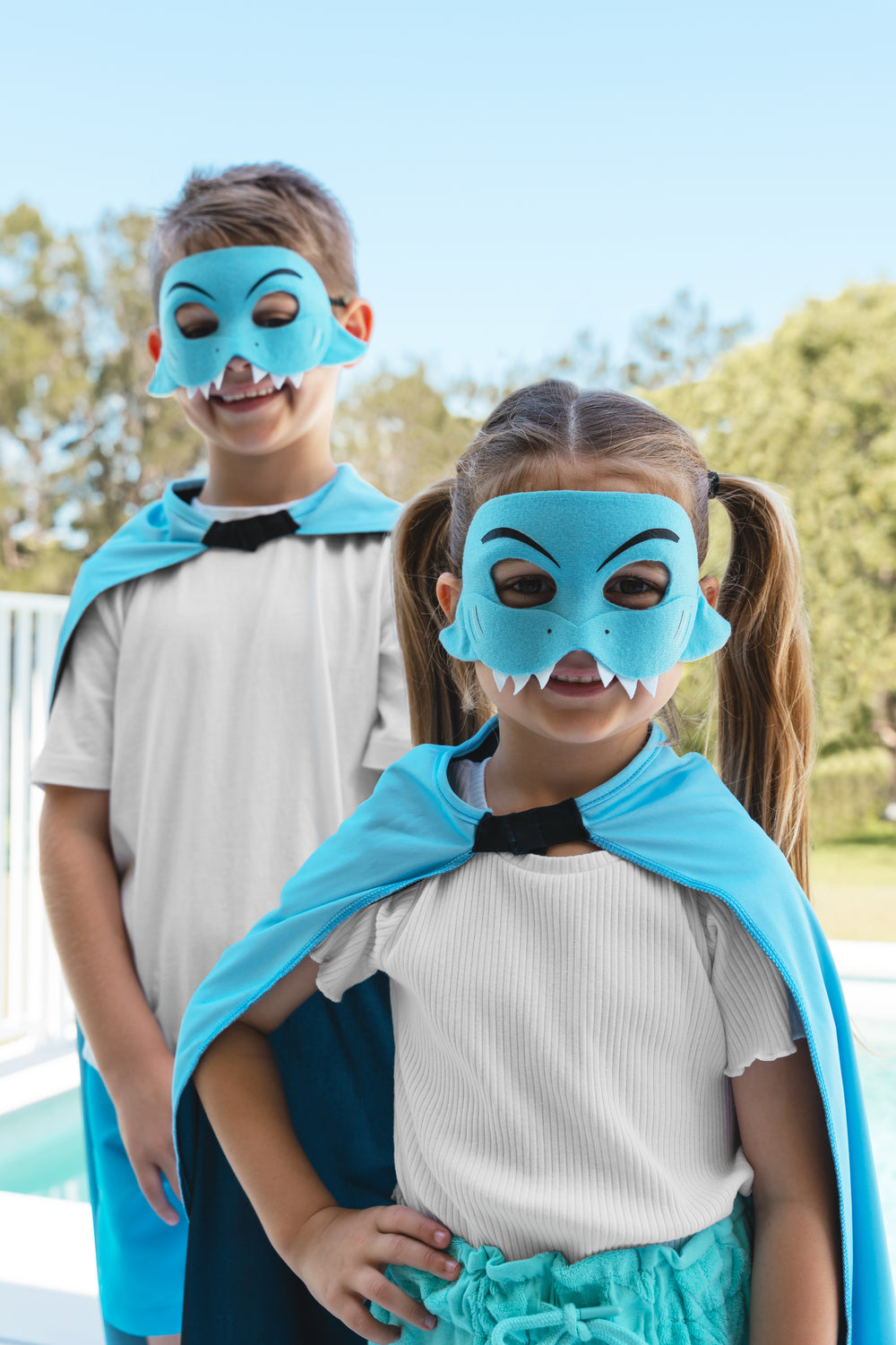Boy and girl wearing the Cronulla Sharks NRL mask and youth supporter cape